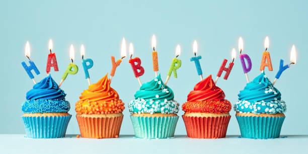 row of orange and blue birthday cupcakes - aniversário imagens e fotografias de stock