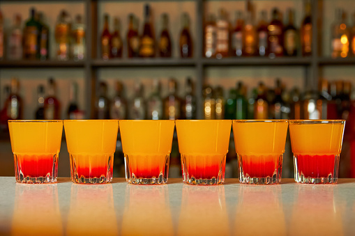 Several multicolored alcoholic drinks shots on the bar counter