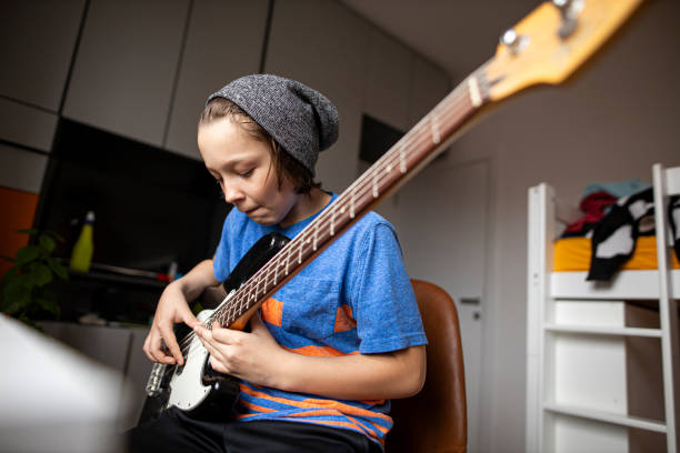 boy playing guitar - practicing piano child playing imagens e fotografias de stock