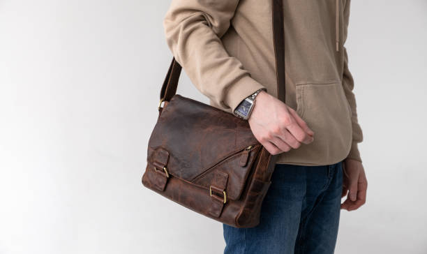 istock Man with a bag made of brown craft leather on a light background 1308894906