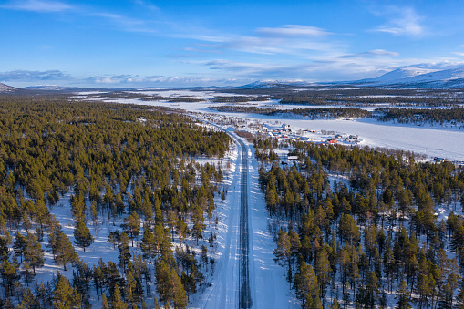 A road leading through a winter landscape in the Kiruna municipality in Lapland, Sweden.