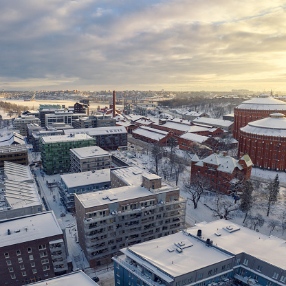 Modern apartment buildings among old refurbished industry buildings along a city street in the Norra Djurgårdsstaden district in Stockholm.