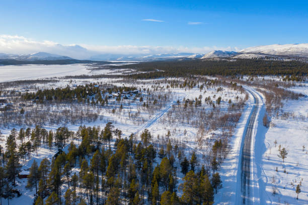 Road to the Scandinavian Mountains A road leading through a snowy landscape leading towards the village of Nikkaloukta and the Kebnekaise massif in the Scandinavian Mountains. norrbotten province stock pictures, royalty-free photos & images