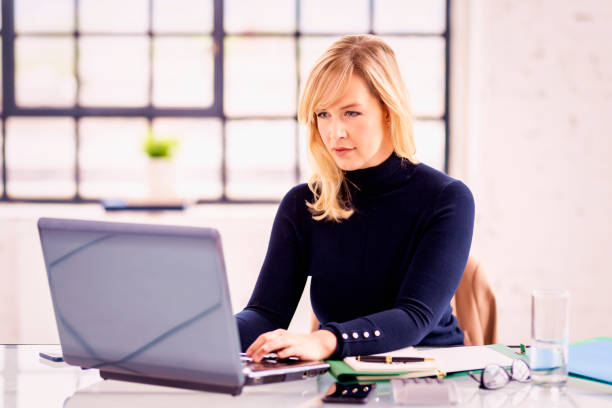 istock Businesswoman working on laptop while sitting at desk 1308896896