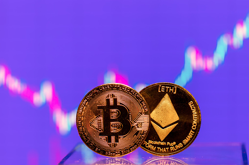Rezekne, Latvia - March 24, 2021: Cryptocurrency bitcoin and ethereum coin displayed on a stock charts with market quotes