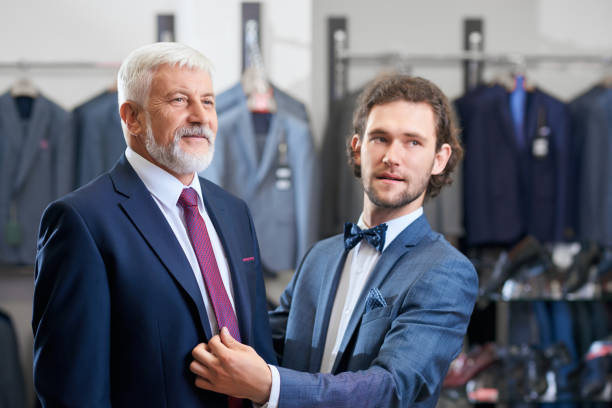 istock Clients choosing fashionable suits in store. 1308898572