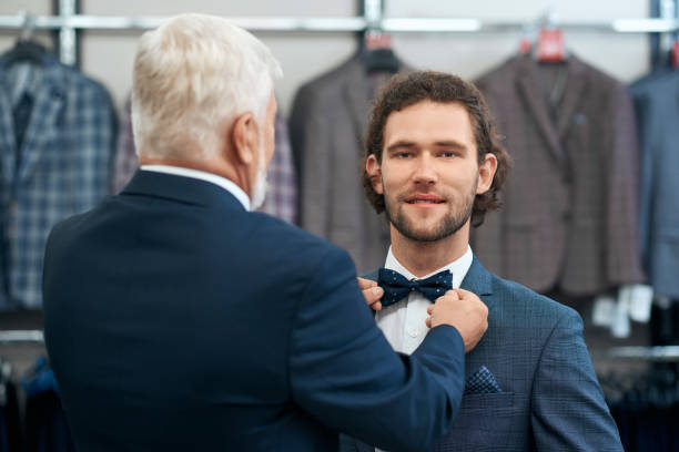 istock Two handsome men choosing bow tie in store. 1308899272