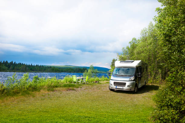 istock Motorhome by the river with a camping table 1308900594
