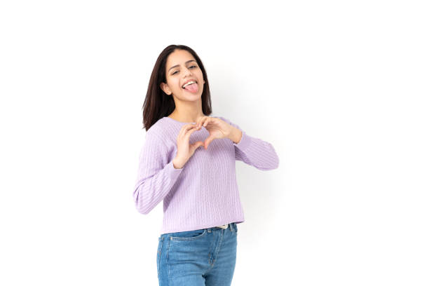 istock Latin woman making heart shape with her hands on white background 1308900950