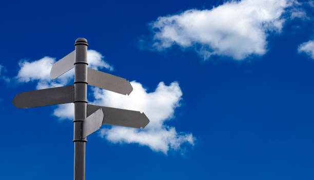 istock Mock up a direction signpost with space for text on the background of a beautiful blue sky with white clouds, the concept of choosing a travel destination. 1308901178