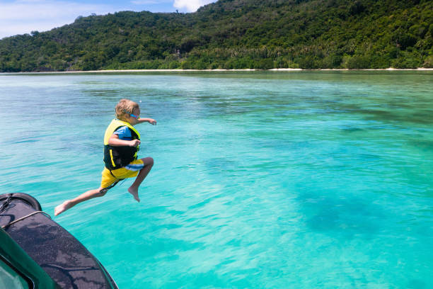 niño saltando al agua del mar. vacaciones en yates. - clear sky water sports and fitness yacht fotografías e imágenes de stock