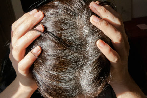 Woman holding her head with her hands White hair, Emotional stress, Economic depression, Head in hands, Sadness gray hair young woman stock pictures, royalty-free photos & images