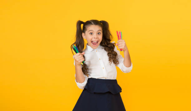istock Studying creativity. Happy little student preparing markers for studying drawing on yellow background. Cute small child studying art in school. Studying is fun 1308907947