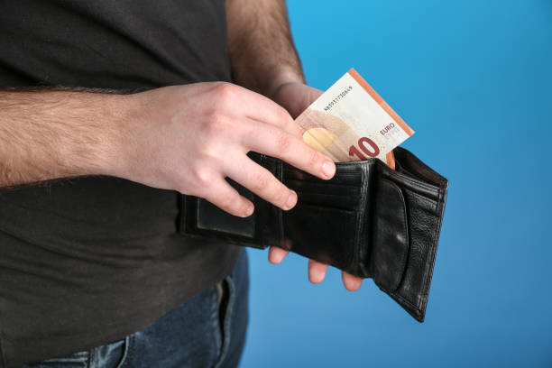 istock man's hand holds wallet with money close up. 1308909237