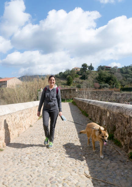 istock Cheerful woman walking her dog 1308909417