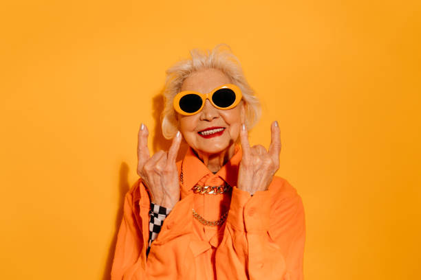 istock Woman standing over isolated yellow background while doing rock symbol 1308910228