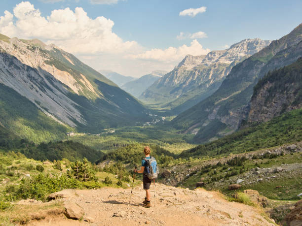 A young man enjoys the view of the mighty mountains of Valle de Pineta in the Spanish Pyrenees Cascadas del Cinco, Faja Tormosa, Nationaal Park Ordesa and Monte Perdido pirineos stock pictures, royalty-free photos & images