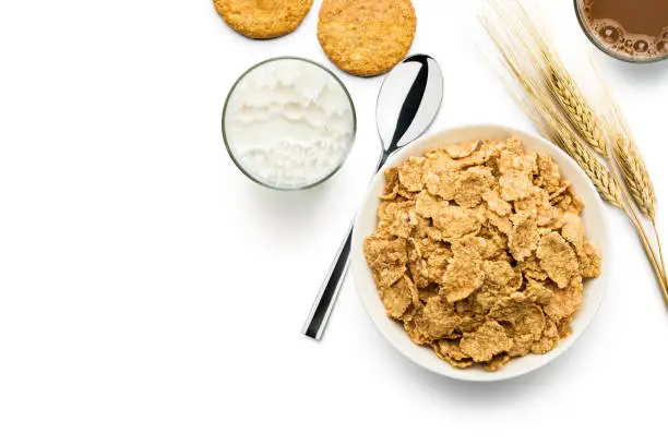 Top view wholemeal cornflakes bowl with milk on white background