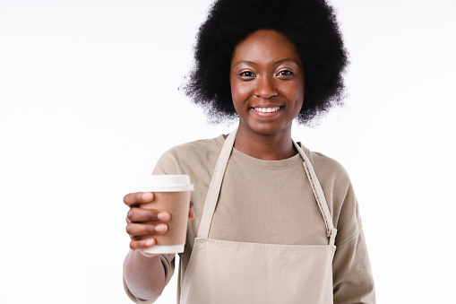 Friendly african teen girl barista with a cup of coffee isolated over white background
