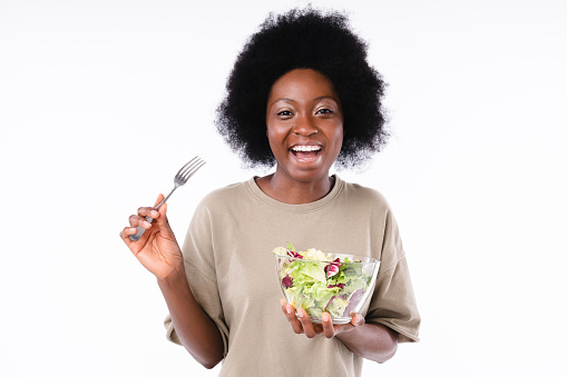 Happy cheerful afro teen girl with a salad isolated over white background