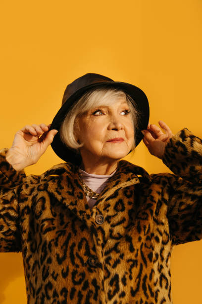 istock Woman wearing leopard fur coat adjusting her hat while standing at the studio 1308915254
