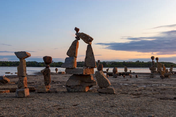 Perfect Spot for Sunrise Yoga Rocks turned into art, balanced on a beach on the Ottawa River at sunrise ottawa river stock pictures, royalty-free photos & images