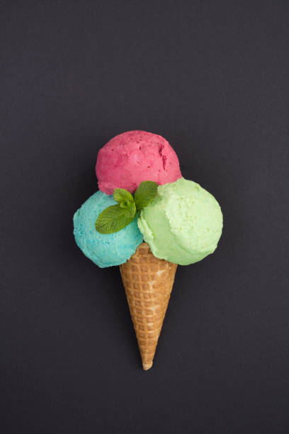 istock Colorful ice cream in a waffle cone on the black background.Copy space. 1308916492
