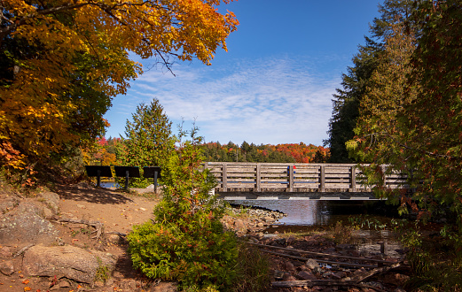 A wooden bridge across Meech Lake in Autumn, in Gatineau Park in Quebec, Canada.