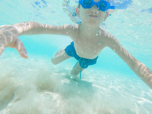 istock Happy kid enjoying while diving in sea 1308920648
