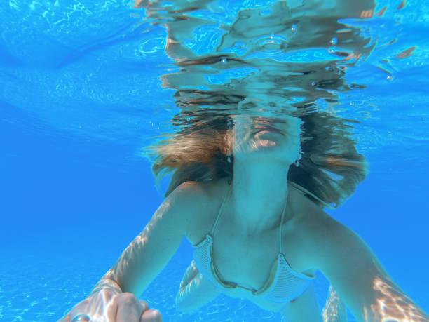 istock Happy women enjoying while diving in sea 1308920745