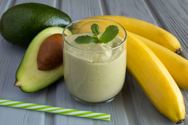 smoothie with avocado and banana on the gray wooden background - cocktail avocado imagens e fotografias de stock