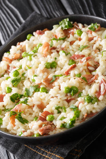 istock Risi e Bisi Italian Rice and Peas with ham close up in a plate. Vertical 1308922432
