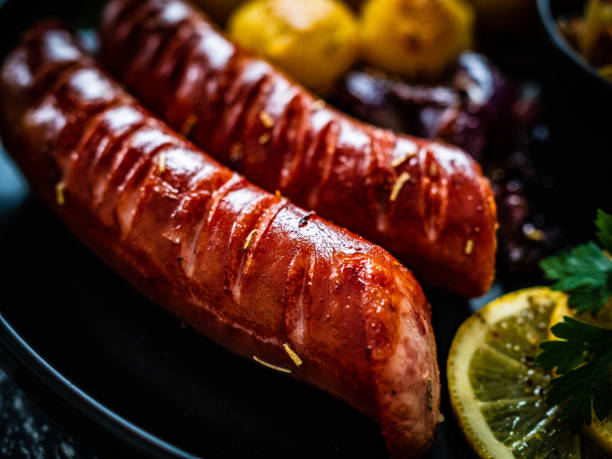 istock Fried sausages and vegetables on black wooden table 1308924402