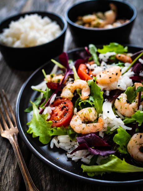 istock Prawn salad - prawns with white rice and vegetables on wooden table 1308925396