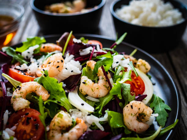 istock Prawn salad - prawns with white rice and vegetables on wooden table 1308926192