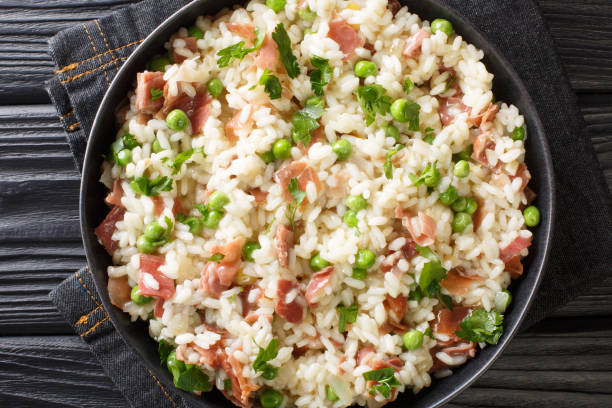 istock Italian risotto Risi e Bisi made from rice with peas and ham close-up in a plate. horizontal top view 1308926234