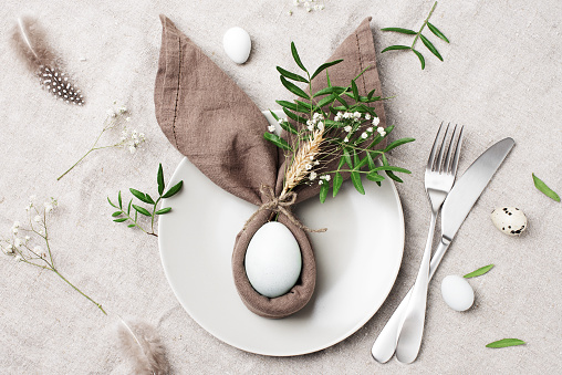 Easter table setting, napkin with bunny ears, natural festive composition