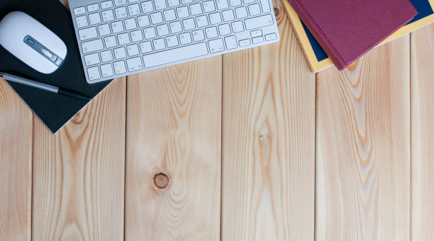 istock working place on the wood table with books, digital mouse, black copybook, pen and white keyboard 1308933280