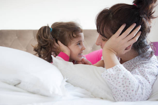 istock Mother and daughter lying in bed 1308935771