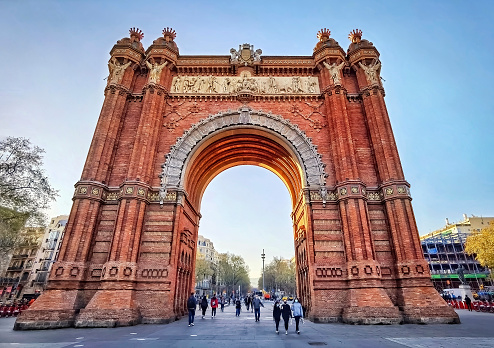 Barcelona, Spain - March 24, 2021: Tourists around the Arc de Triomf at sunset