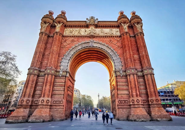 Barcelona, Arc de Triomf, Spain Barcelona, Spain - March 24, 2021: Tourists around the Arc de Triomf at sunset arc de triomf barcelona photos stock pictures, royalty-free photos & images