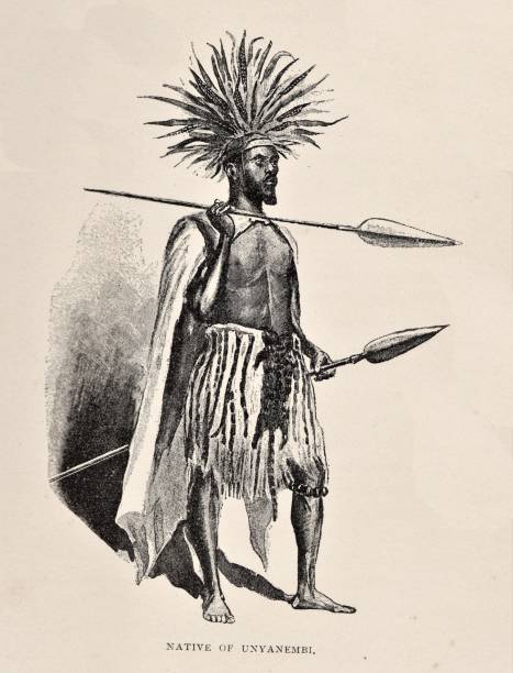 African Native of Unyanembi, Africa in 19th Century Full-length portrait of an indigenous African man of the Unyanembi tribe in Africa in 1870s. The native wears a feather headdress and carries spears. Illustration published 1891. Source: Original edition is from my own archives. Copyright has expired and is in Public Domain. african warriors stock illustrations