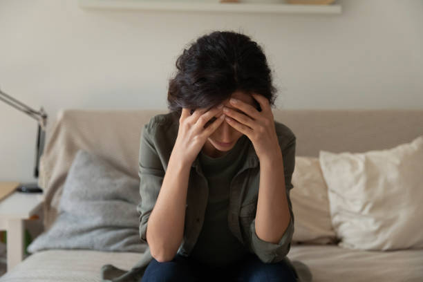 istock Frustrated depressed millennial woman sit on couch alone hug head 1308937434