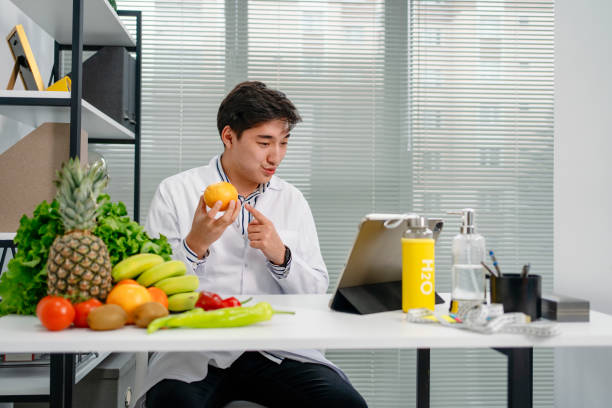 ernährungsberater verwendet ein digitales tablet, um eine online-konsultation mit seinem patienten durchzuführen - ernährungsberater stock-fotos und bilder