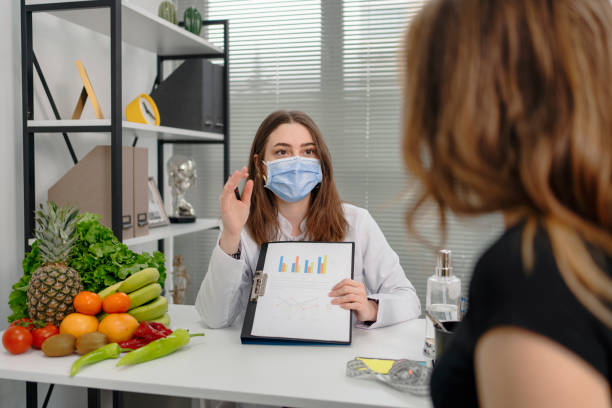 istock dietitian holding diet plan during consultation with patient in the office 1308939893