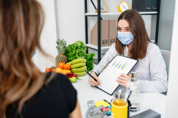 dietitian holding diet plan during consultation with patient in the office