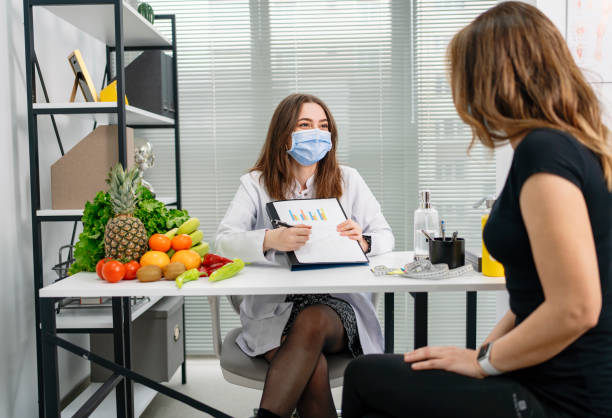 istock dietitian holding diet plan during consultation with patient in the office 1308940436