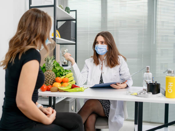 istock dietitian holding diet plan during consultation with patient in the office 1308940540