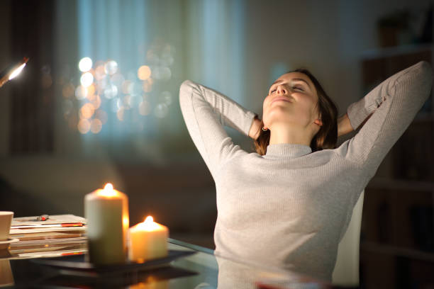 entspannte frau ruht in der nacht mit kerzen - aromatherapie stock-fotos und bilder