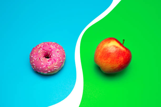 istock Donut and apple on the blue background. Choosing between apple and donut. 1308941869